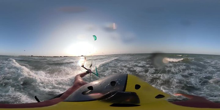 A first-person view, the moochina kitesurfer rushes by the sea at dawn leaving behind a splashes