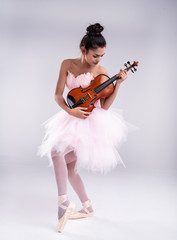 The beauty lady is wearing pink ballet suit,dancing with wooden violin,with happy feeling