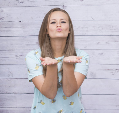 white, girl with long hair sends air kiss, joyful facial expression,