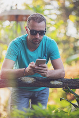 Fototapeta premium Modern man using cellphone outdoors.