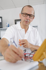 repairman holding glasses busy in his workshop