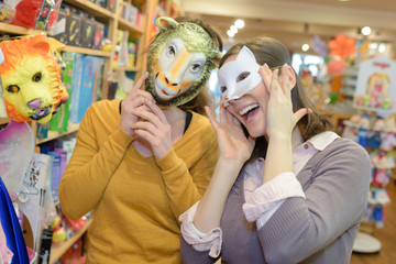 attractive friends with masks in toy store