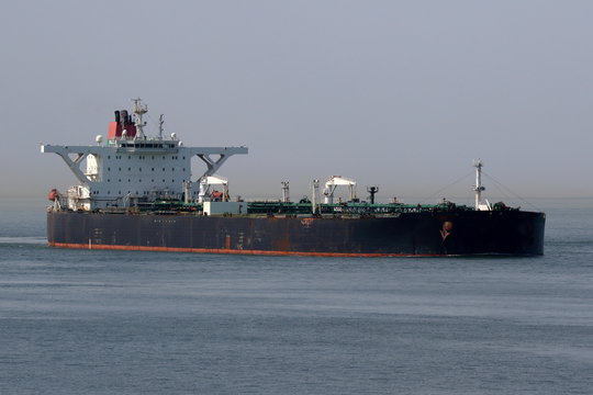 schwarzer Supertanker l&auml;uft in Hafen ein