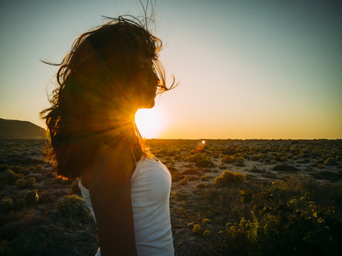 Beatiful Carefree Young Woman With Wind In Her Hair At Beach Nature. Hipster Girl With Hairstyle Enjoy Summer Sunset Fun. Happy People Traveling Lifestyle Concept. 