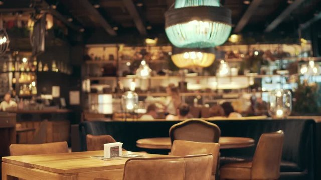 Blurred restaurant or cafe background. Tables and chairs. Visitors to the family restaurant for dinner. Beautiful bright interior. Blurred background bokeh background for design    