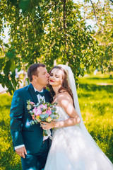 Marriage concept. Bride and groom kissing outdoor. Newlyweds couple in love. Wedding couple in love uner veil. Sunny day. Before wedding ceremony.