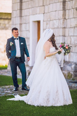 Wedding day. Beautiful fairytale newlywed couple hugging near old medieval castle. Sensual married couple bride and groom valentines hugging in front of old castle wall.