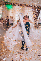 First wedding dance of newlywed. Bride and groom dancing around a lot of confetti.