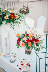 Table set for wedding or another catered event dinner. Catering in restaurant for wedding party. Served tables with pink and red flowers. 