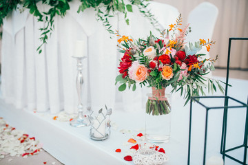 Table set for wedding or another catered event dinner. Catering in restaurant for wedding party. Served tables with pink and red flowers. 