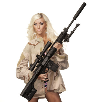 Beautiful young blonde model holding army style machine gun