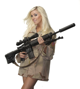 Beautiful young blonde model holding army style machine gun