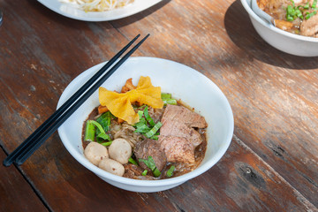 Noodles soup with beef Thai food style name Boat Noodles on wooden table