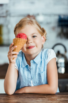 Cute Happy Kid Holding Delicious Sweet Ice Cream Cone And Smiling At Camera