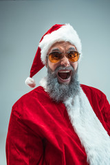 Funny serious guy with christmas hat posing at studio. New Year Holiday. Christmas, x-mas, winter,...