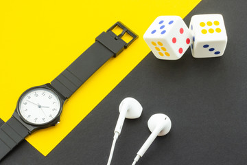 Dice, headphones and a clock on the background