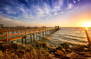 Fototapeta na wymiar Long wooden docks reach into Galveston Bay, Texas, at sunrise