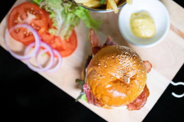 Hamburgers and French fries on the wooden tray.
