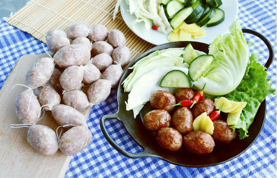 Easten thai sausage (Thai name is Sai Krok Isan) cooked and uncooked  with fresh vegetable.
ground pork with vermicelli,Rice and garlic  Sausage.