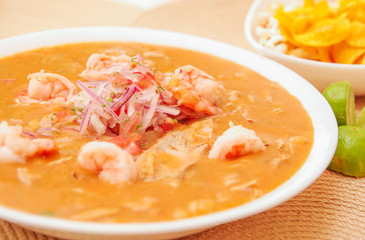Close up of selective focus of Ecuadorian food: shrimp cebiche with some blurred chifles background