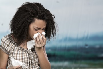 Young afro american girl sneezing on background