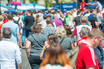Crowd of people walking on city street 