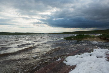Fototapeta na wymiar Stormy lake with lots of foam. Copy space. Concept of travel