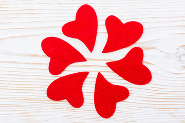 Flower of petals - red hearts on a white wooden background