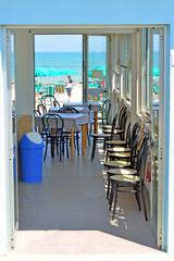 veduta dell'interno di un bar,  sullo sfondo il mare