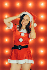 Party, celebration, Christmas and New Year. Beautiful girl wearing red Santa Claus hat. Sensual Christmas girl on red background. Sexy Santa helper girl. New year, Christmas time, holiday celebration.