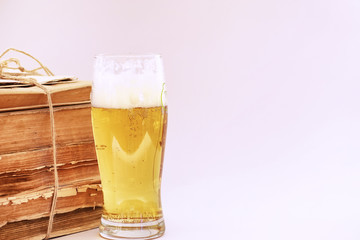 A stack of vintage books and a mug of light beer