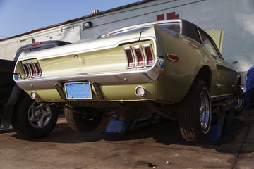 Rear view of a classic vintage American muscle car on the lift in a garage