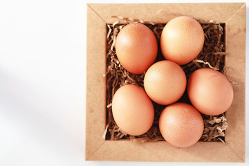Chicken brown eggs on a white table