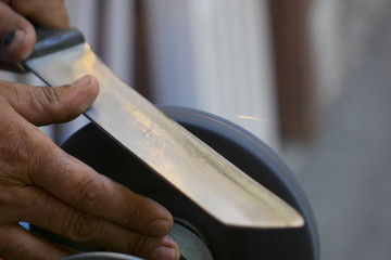 Man grinding on abrasive cutting and knife-sharpening stones