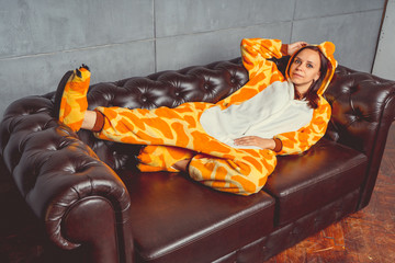 Pajamas in the form of a kangaroo. emotional portrait of a student on the background leather sofa....