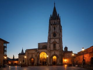 Fototapeta na wymiar Illuminated cathedral of Oviedo with blue sky at daybreak, Spain