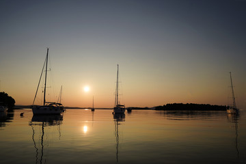 Naklejka na ściany i meble Sunset with sailingyachts