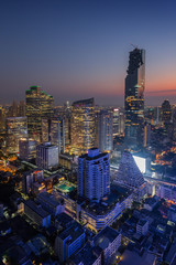 Fototapeta premium Scenic view of MahaNakhon and many other lit skyscrapers in downtown Bangkok, Thailand, from above in the evening.