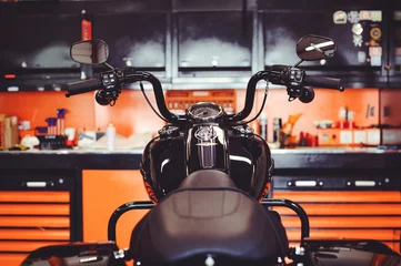Foto auf Acrylglas Motorrad Motorräder auf dem Boden mit Werkstattwerkzeug, eine moderne Garage, Lagerung und Reparatur. Dieses Fahrrad wird perfekt sein. Reparatur eines Motorrads in einer Werkstatt