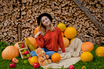 The girl sits next near for pumpkins. Thanksgiving, Halloween