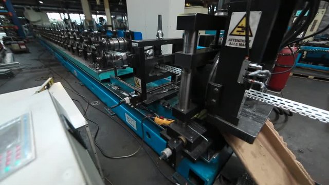 Profiles are created on the metal rolling machine at the plant. creation of profiles, machine for creation of steel profiles from steel sheet. close-up