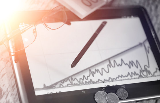 The graph of income growth. Electronic tablet with a graph of gr