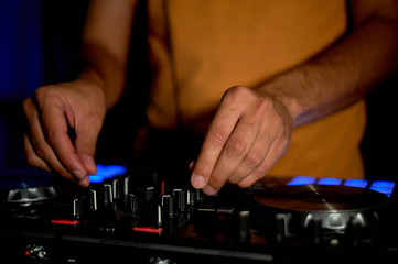 DJ remote, turntables, and hands . Night life at the club, party