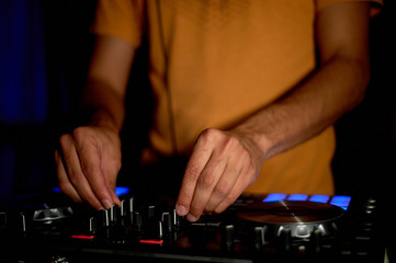 DJ remote, turntables, and hands . Night life at the club, party