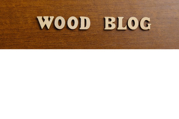 WOOD BLOG. An inscription made of wooden letters against the texture of a dark brown wood. White copyspace.