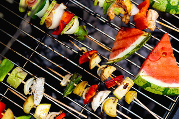 Grilling watermelon and shish kabobs with chicken, potatos and other vegetables