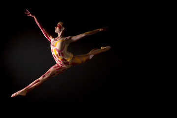 Naklejka premium Mujer joven haciendo danza contemporánea sobre fondo negro en estudio