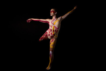 Mujer joven haciendo danza contemporánea sobre fondo negro en estudio