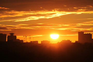 Fototapeta premium Cityscape with silhouette of city skyline against setting sun. Minsk, Belarus