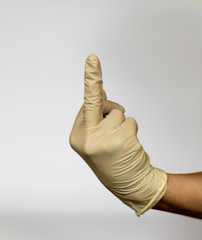 Hand in medical light yellow latex glove isolated on white background. Medicine. Medical manipulations. Рantomime.